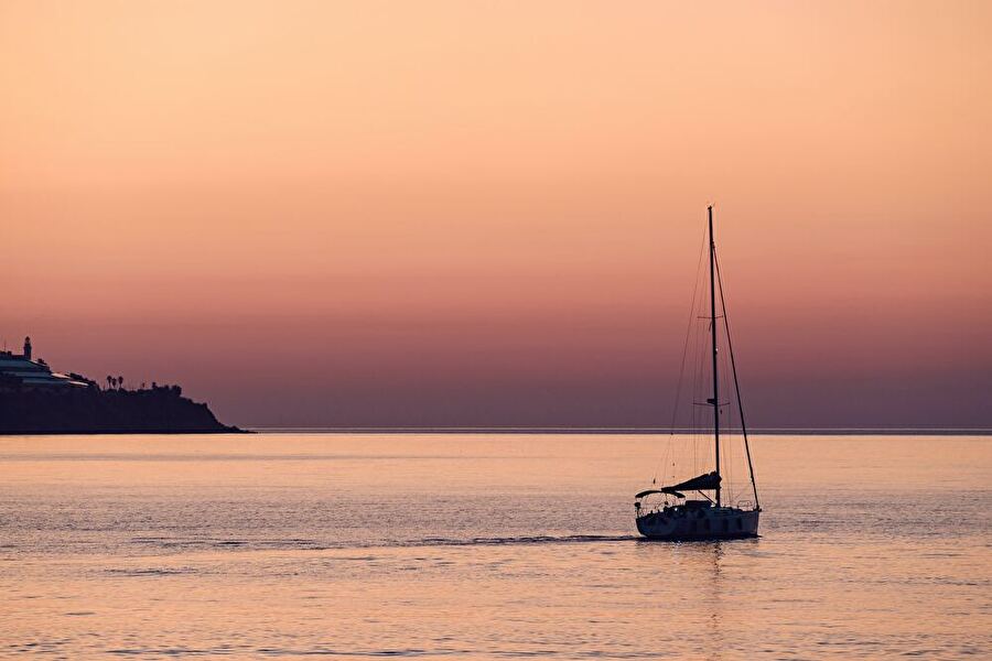 scene of sunset with sailboat